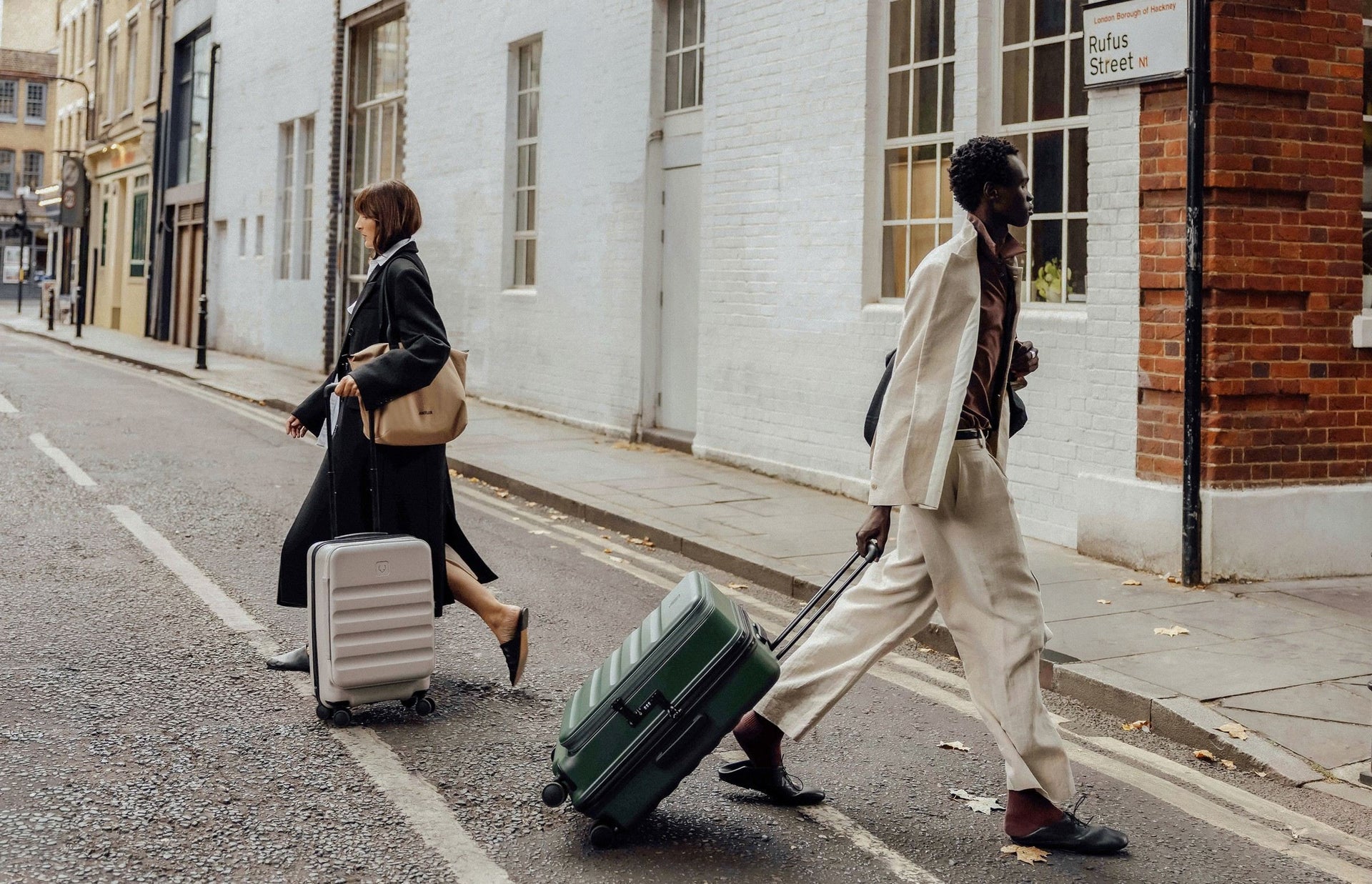 Travellers crossing a city street with luggage